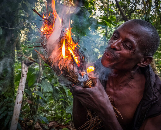 USAID Measuring Impact Conservation Enterprise Retrospective September 2017. The Batwa Pygmies were evicted from their home lands in the forest in the early 1990s when the National Parks were established, leaving them landless and poor in a society that saw them as a lower class. Today some of them try to make ends meet by hosting trail walks; cultural tours that include examples of where and how they use to live in the forest as well as singing, dancing, and handicrafts for sale. Buhoma, Uganda. Photograph by Jason Houston for USAID